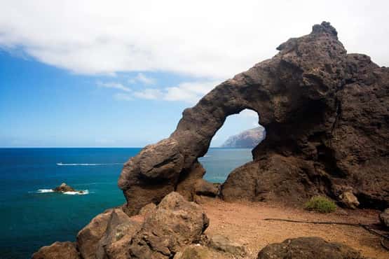 Rock arch, natural hole in pillow lava cliffs makes a popular tourism feature for photographs, Los Gigantes, Tenerife, Canary Islands, April