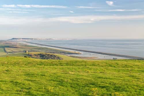 Overview of St. Catherine’s Chapel, Abbotsbury, The Fleet Lagoon and Chesil Beach looking east towards the Isle of Portland, Dorset, UK, October 2023