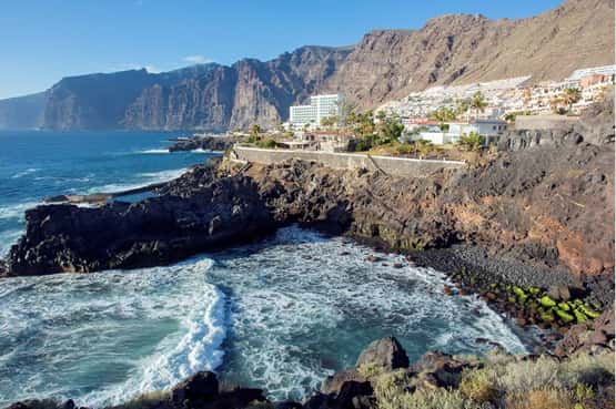 Acantilado de Los Gigantes, huge basaltic cliffs on the rugged Atlantic coast tower over a small  pretty white holiday resort, Los Gigantes, Tenerife, Canary Islands, April