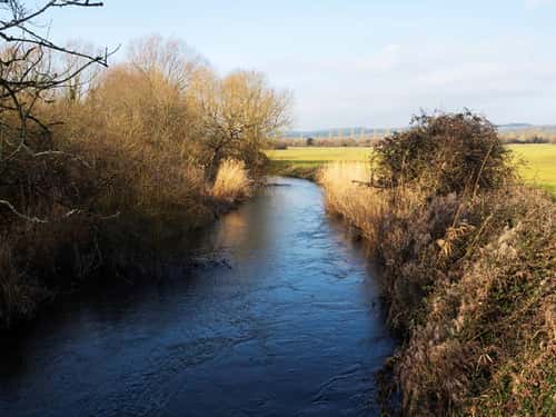 River Frome and farmland near Woodsford, Dorset, England, UK, February