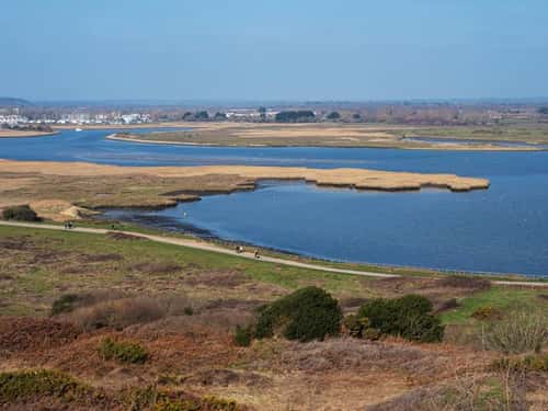 Looking across Christchurch Harbour and Stanpit Marsh Nature Reserve with the River Stour and Christchurch beyond, Hengistbury Head, Dorset, England, UK, March